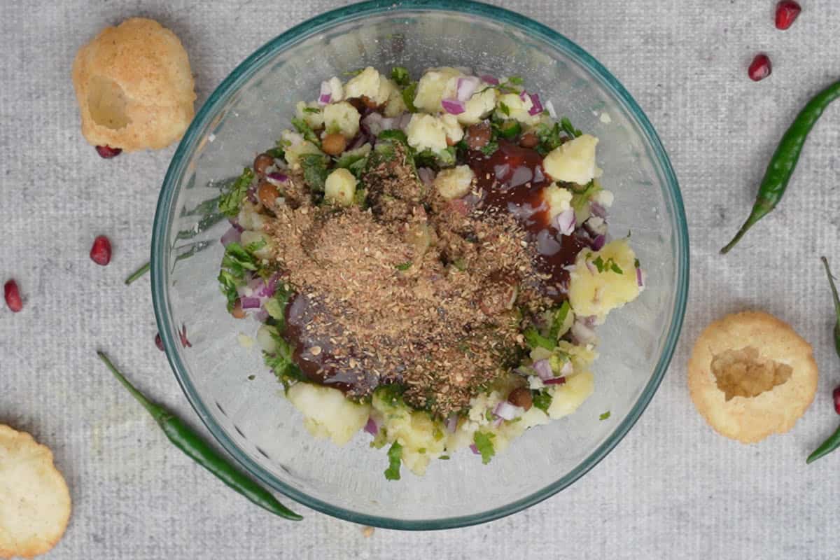 Bhaja masala, tamarind chutney and green chutney added to the bowl.