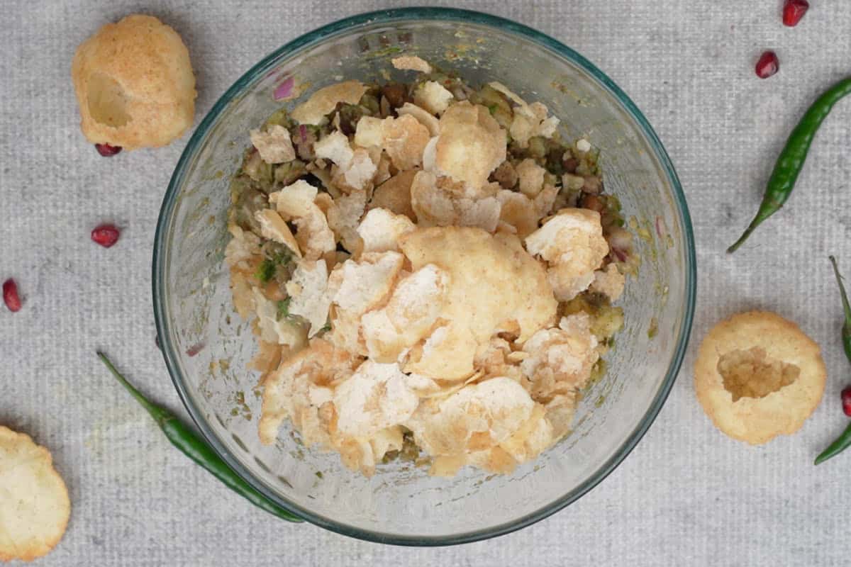 Puchkas crushed over the potato mixture.