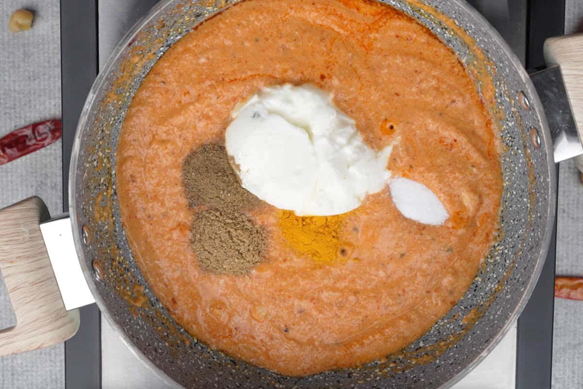 Onion tomato paste, yogurt and spice powders added to the pan.
