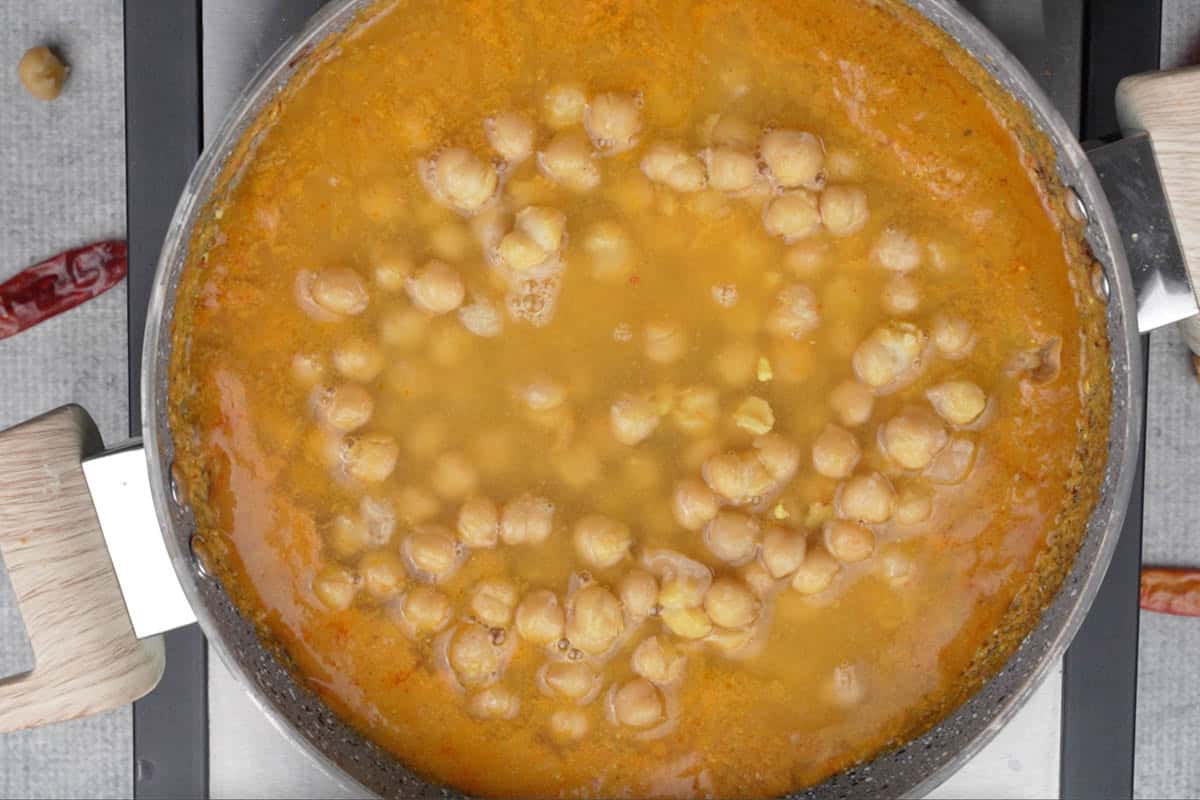 Cooked chole and water added to the pan.