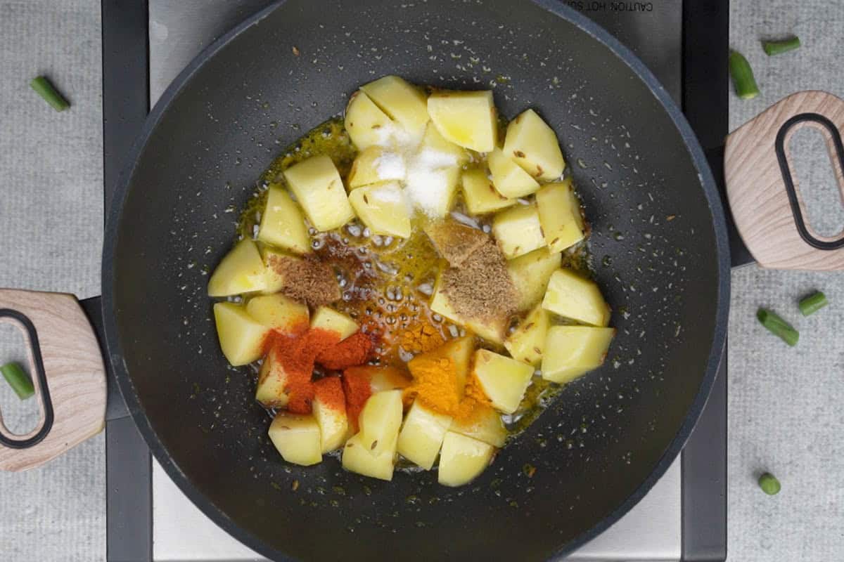 Spice powders added to the pan.