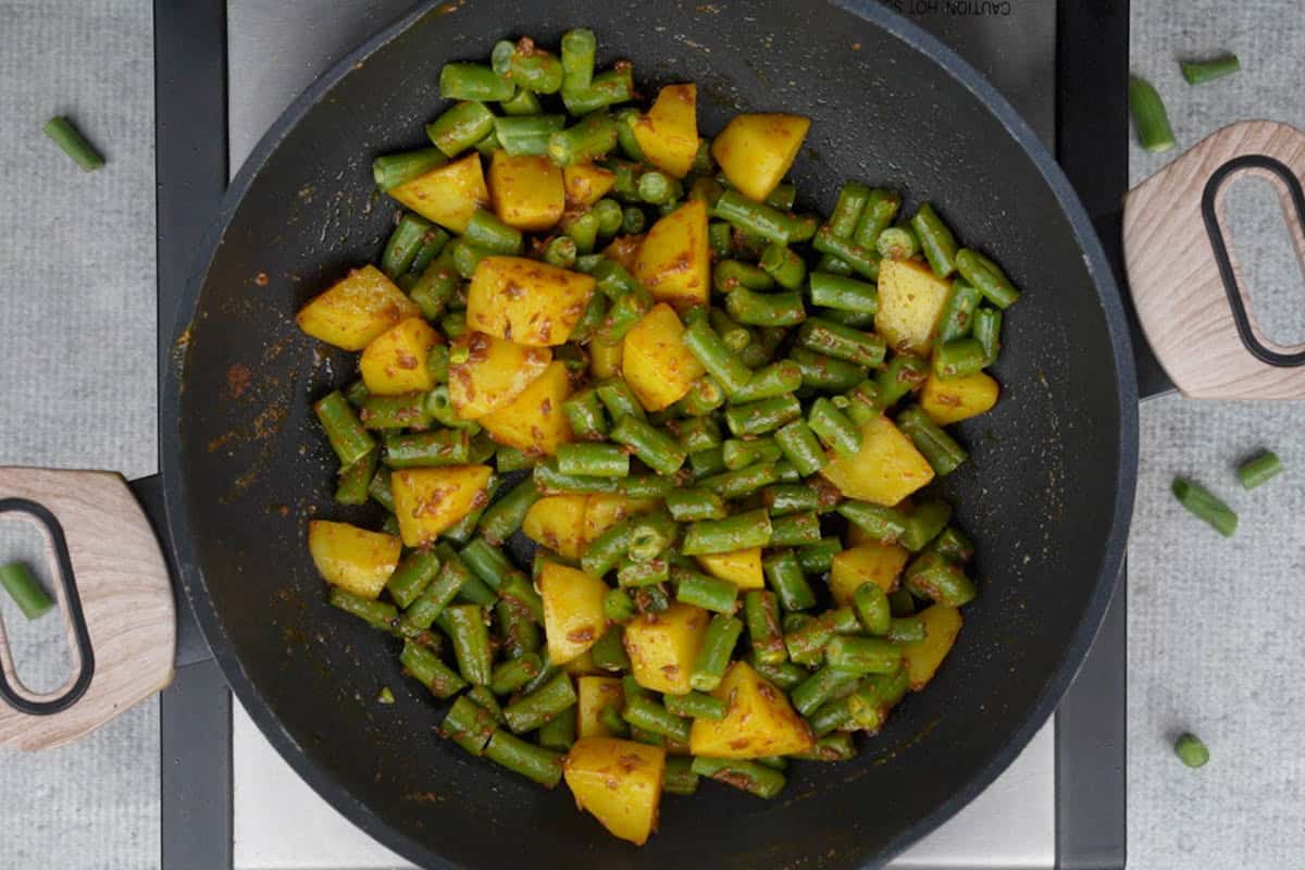 French beans added to the pan.
