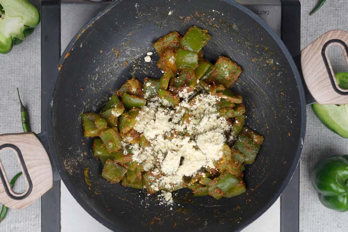 Roasted besan added gradually to the pan.