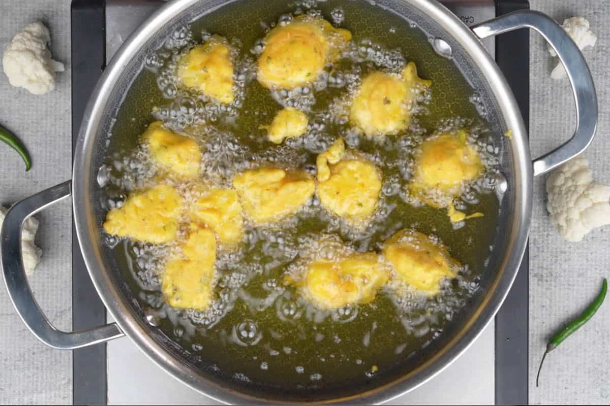 Frying the besan batter coated gobi in hot oil.