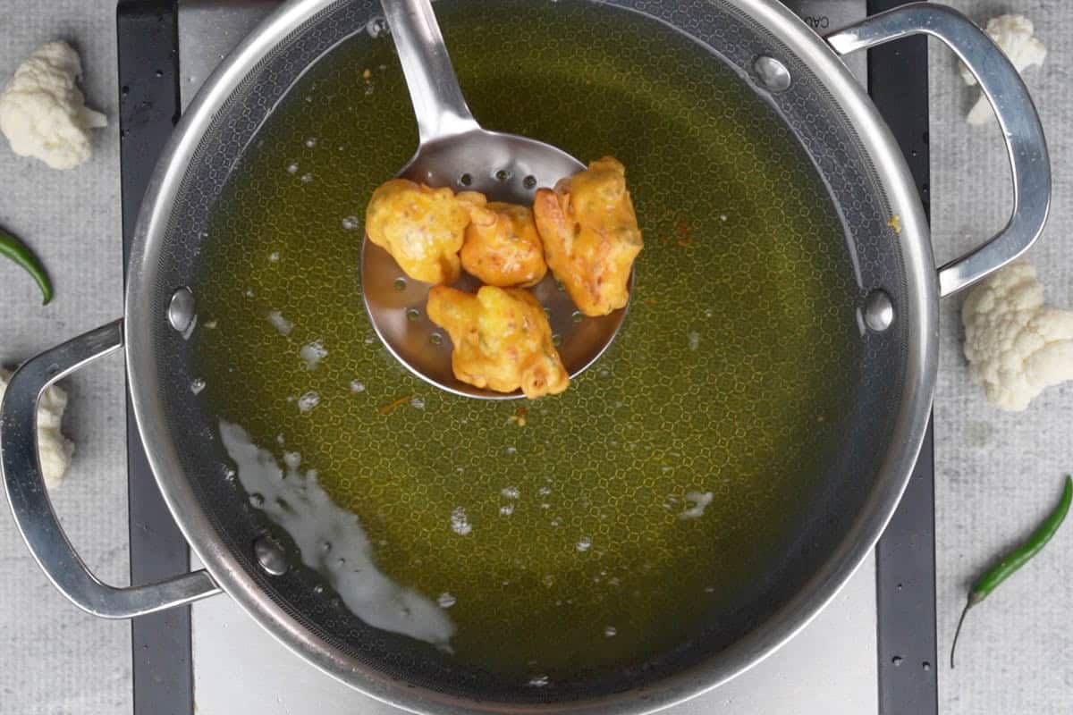 Draining the ready gobi pakora from oil.