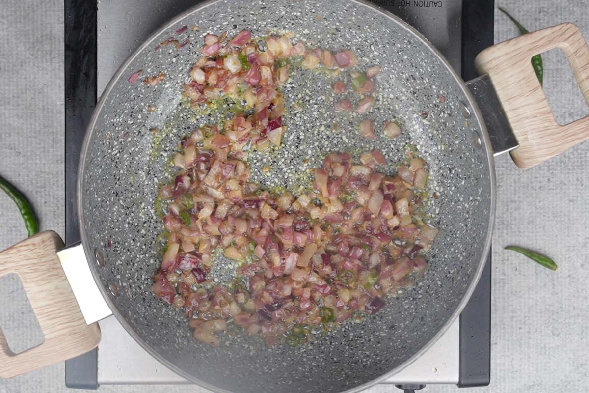 Onion, green chilies, and ginger added to the pan.