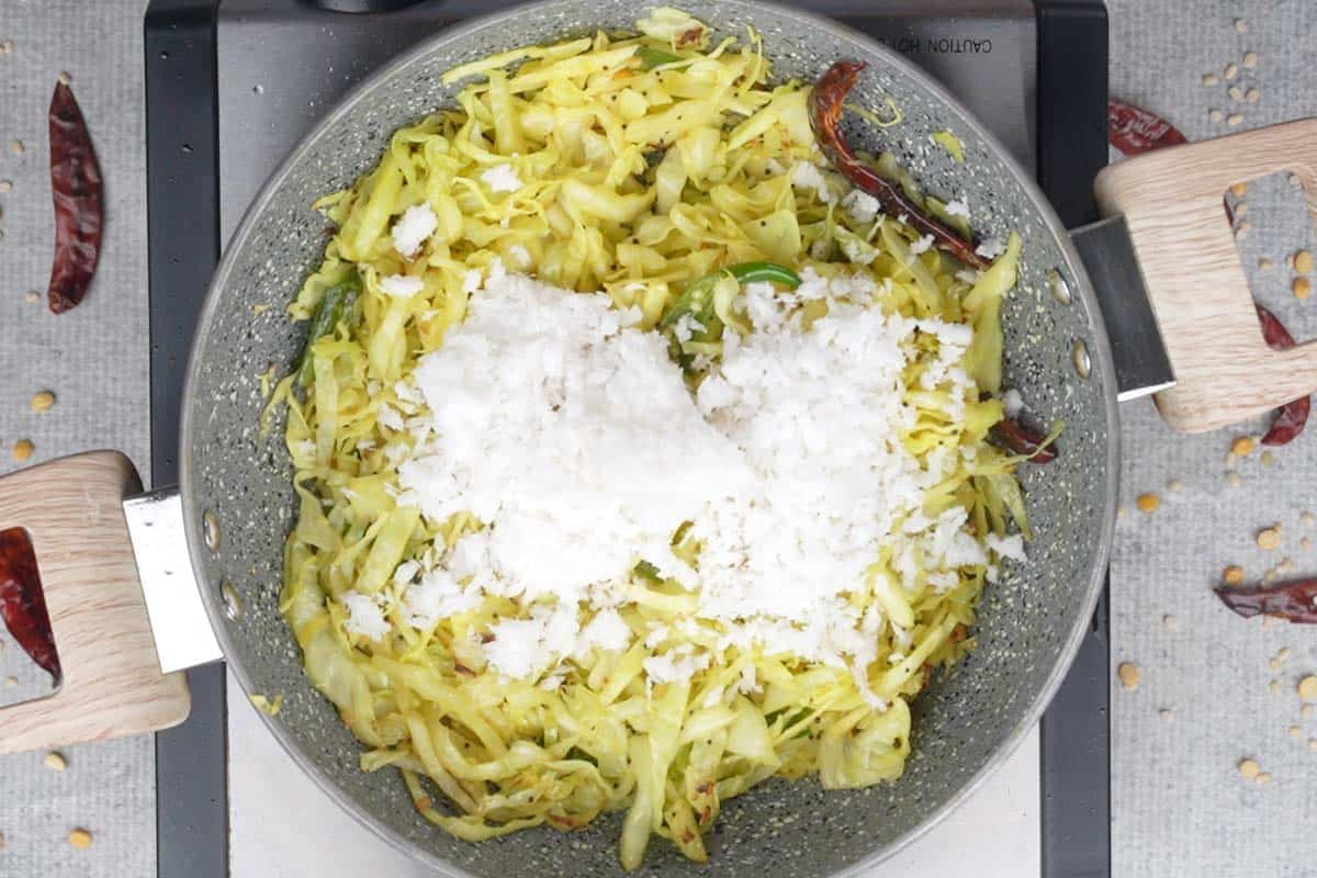 Grated fresh coconut added to the pan.