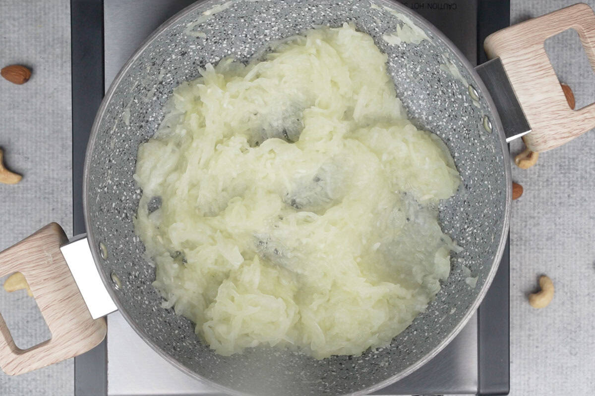 Grated lauki sauteed in a pan.