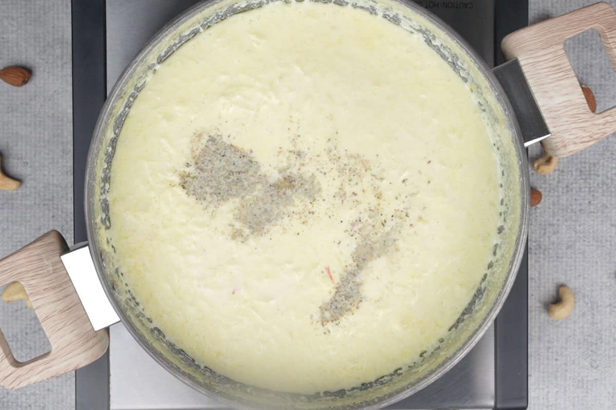 Sugar, cardamom powder and rose water added to the pan.