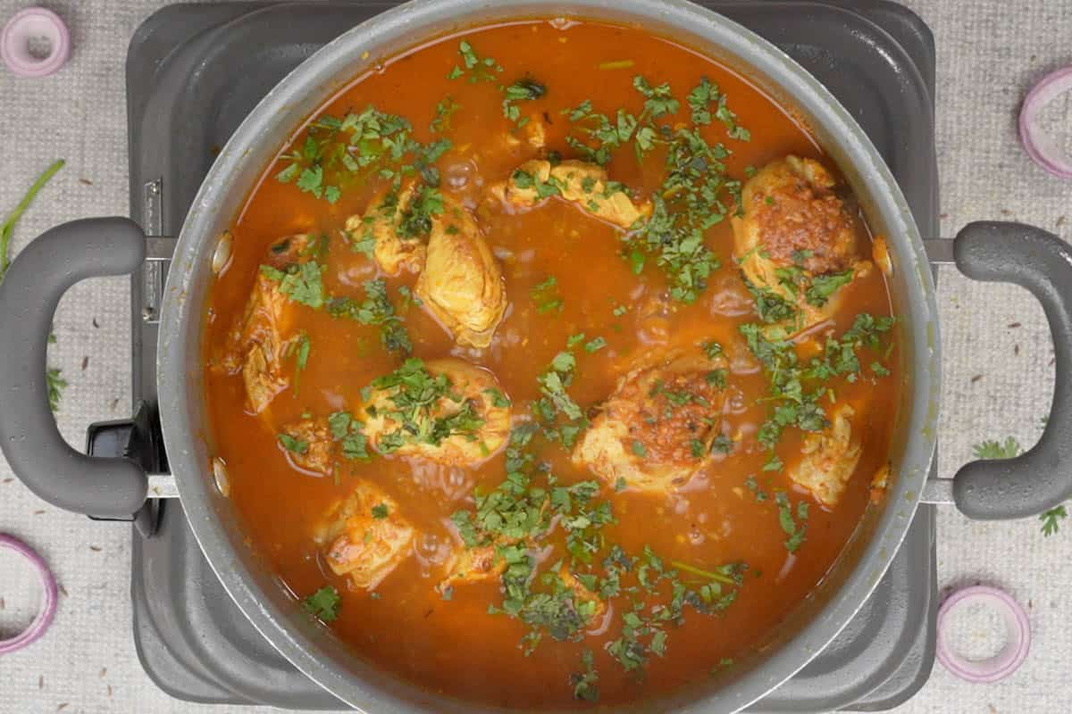 Ready pahadi chicken curry garnished with chopped cilantro.