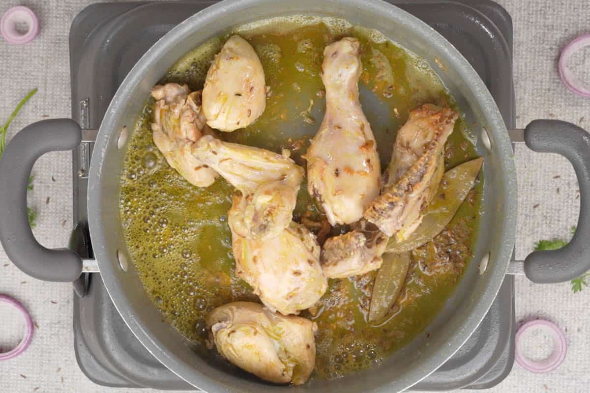 Chicken pieces sauteed in the pan.