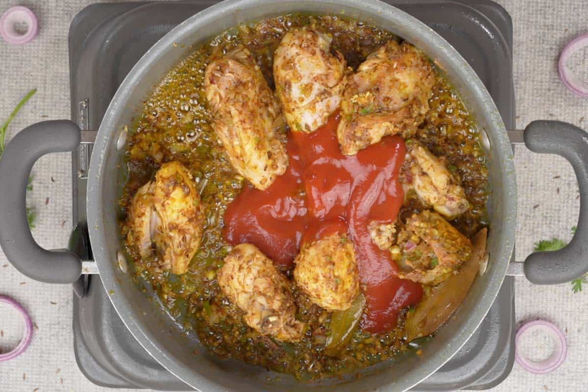 Pureed tomatoes and hing water added to the pan.