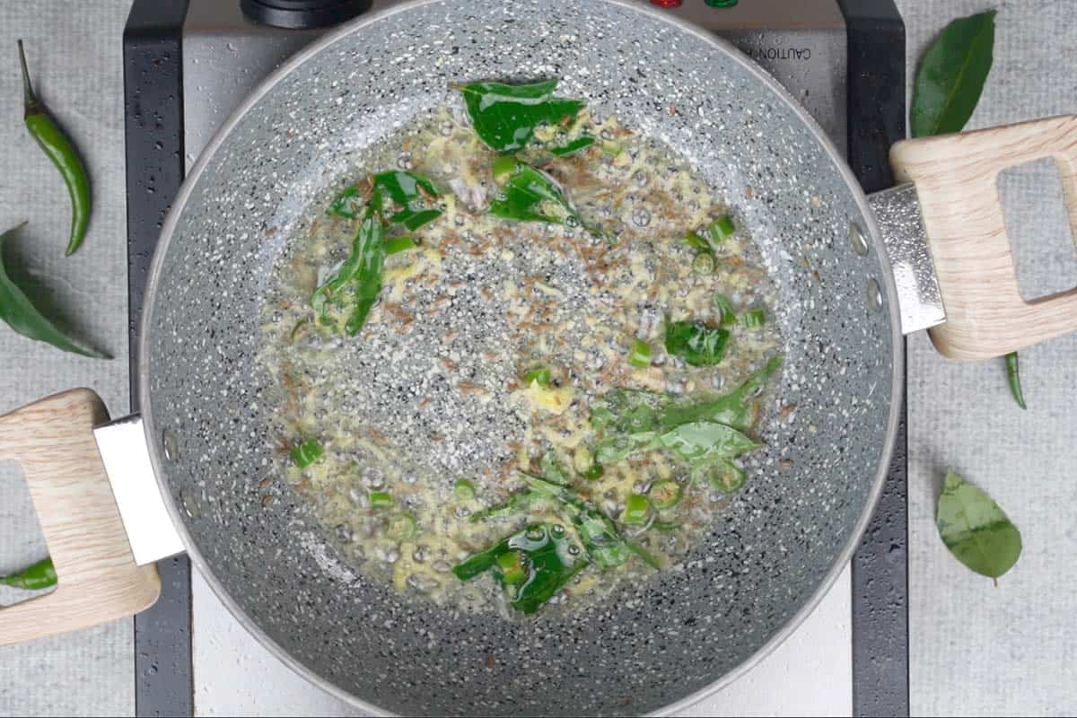 Ginger and green chilies added to the pan.